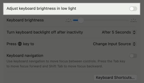 Adjust Keyboard Brightness in Low Light option in MacBook System Settings.