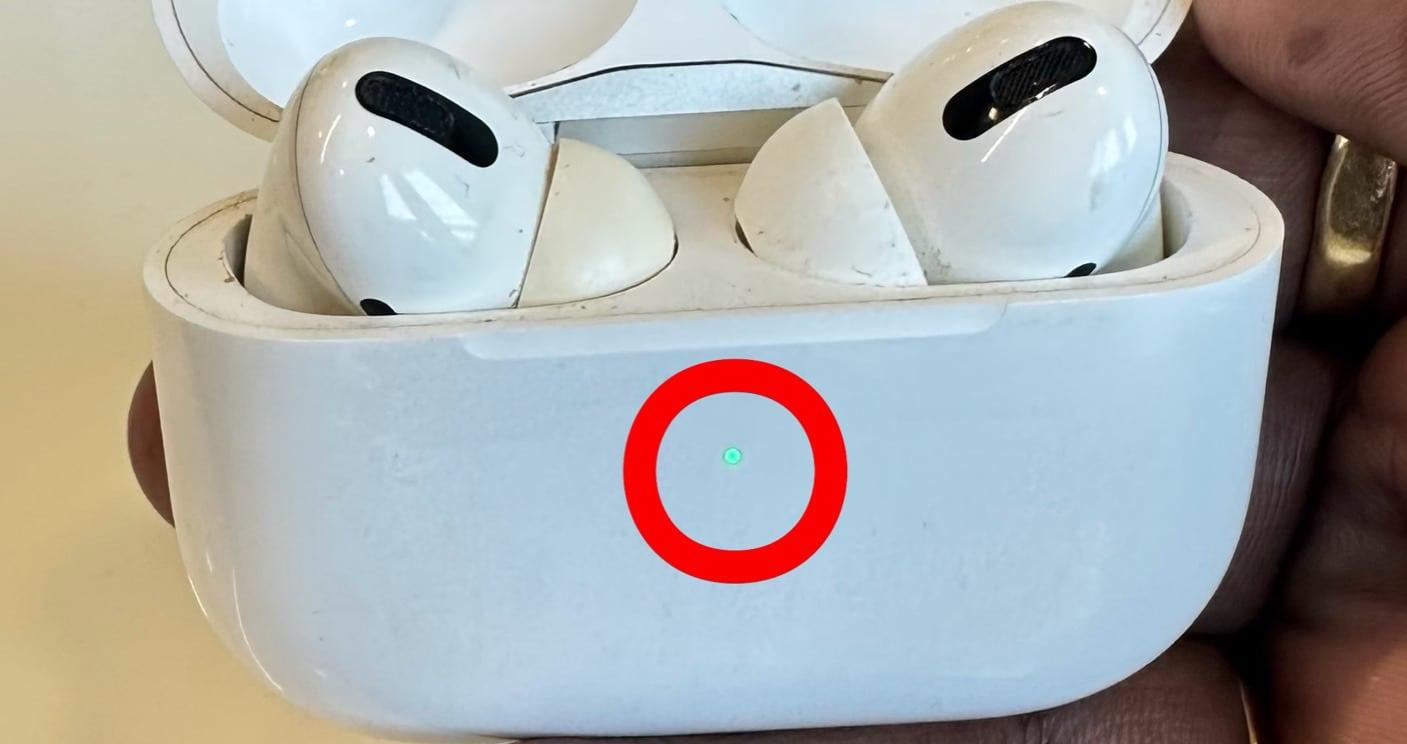 Green LED indicator on AirPods indicating battery fully charged.