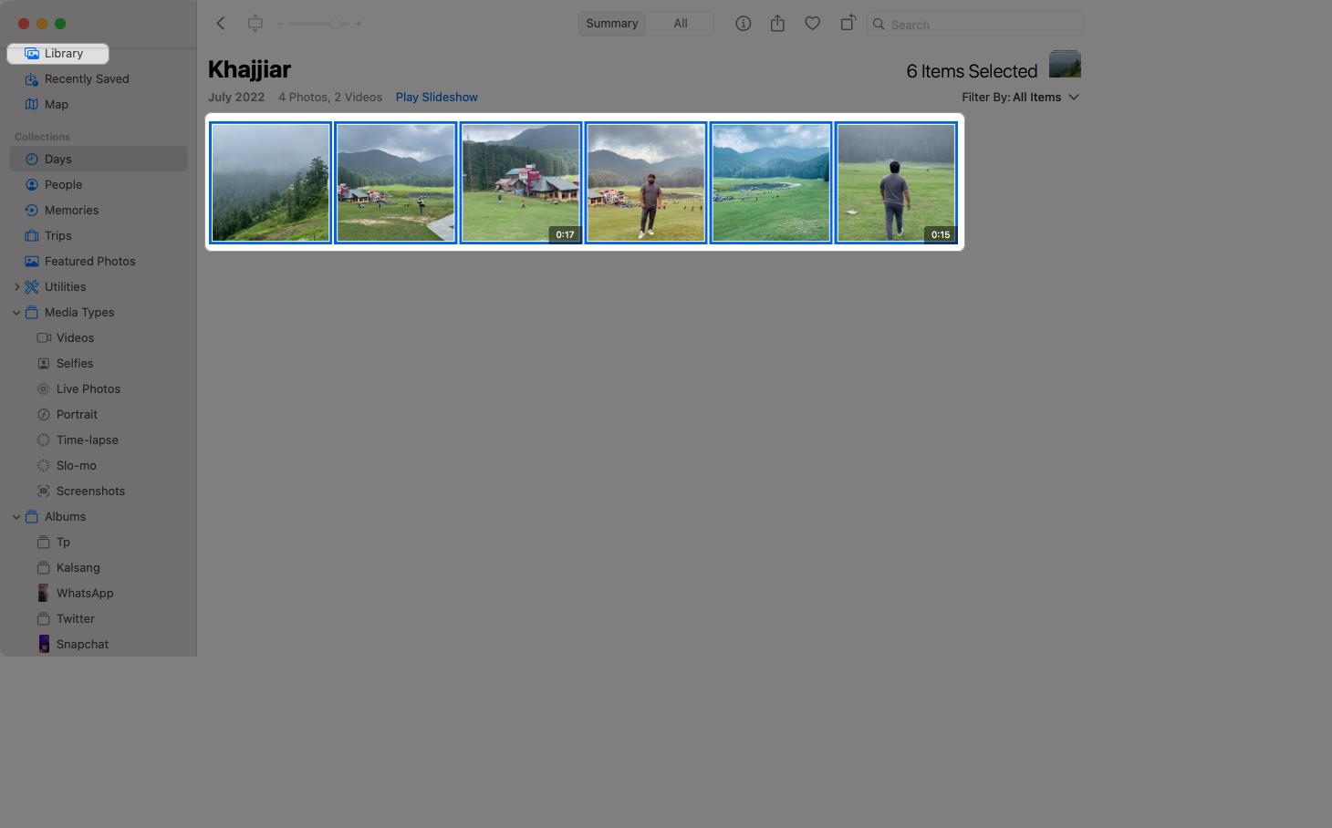Choosing photos and videos to add to a slideshow in Photos app.