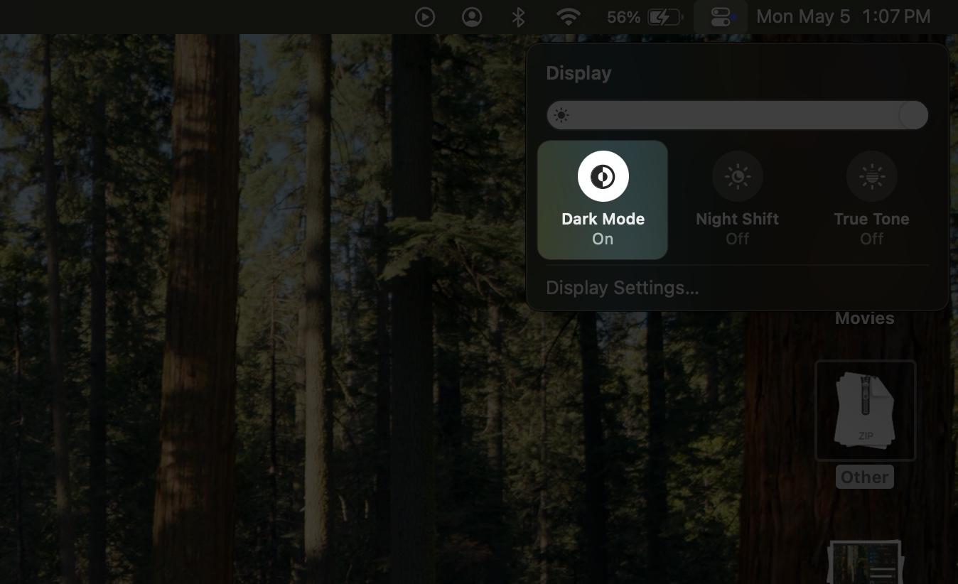 Clicking the Dark Mode icon in Control Center on a Mac.