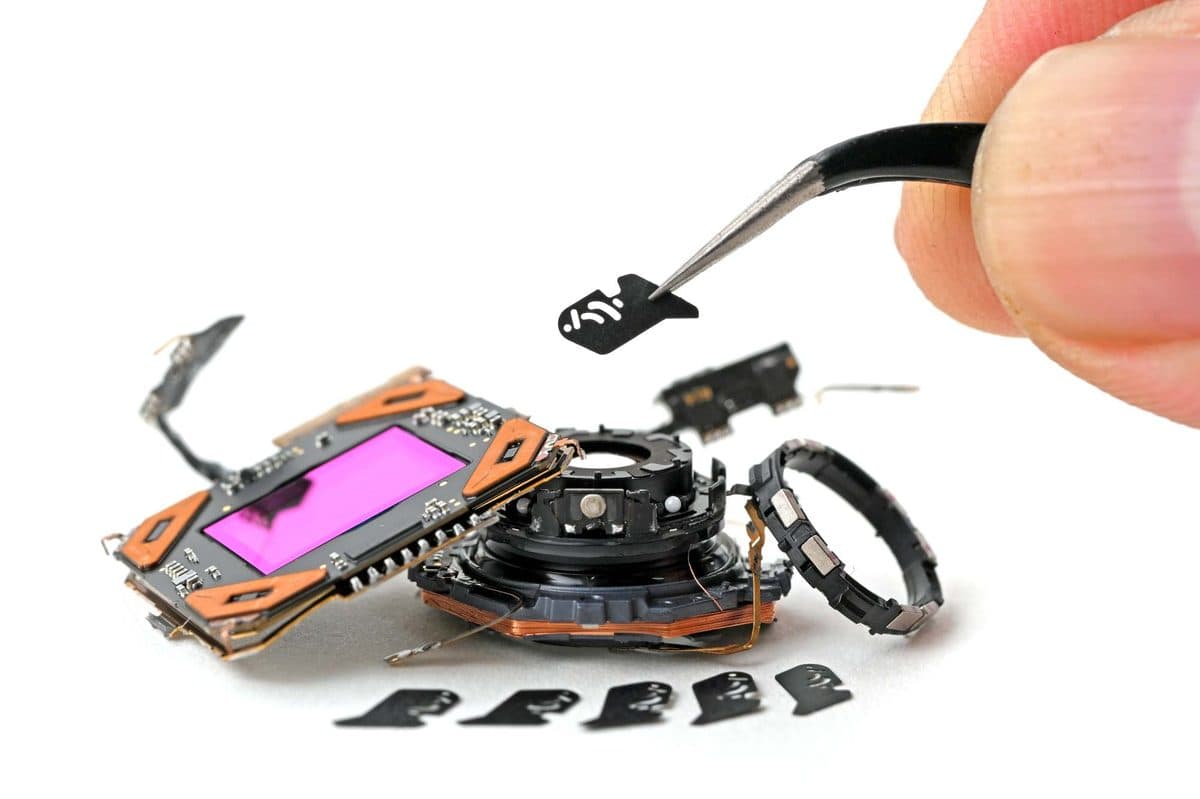 Close-up of iPhone 18 Pro variable aperture with six polymer blades disassembled on lab surface