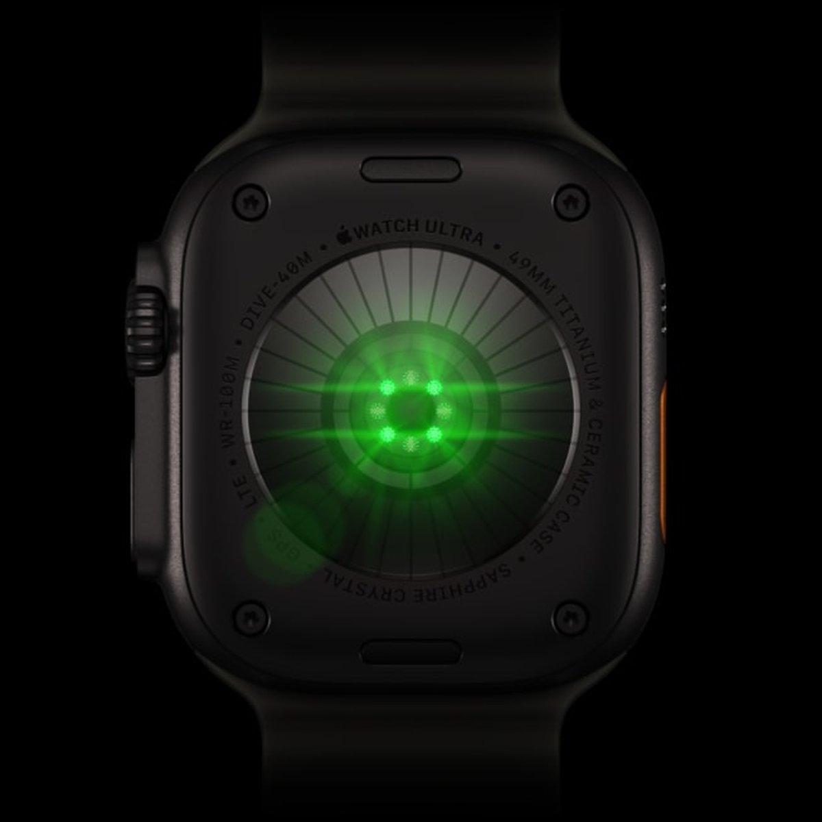 Back of Apple Watch Ultra 4 with its green heart-rate sensor illuminated.