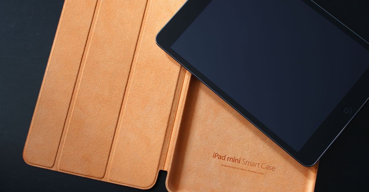 An iPad mini in a tan leather Smart Case on a dark background