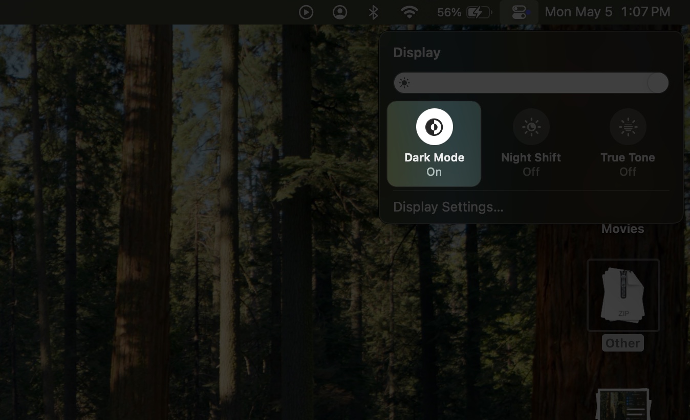 Clicking the Dark Mode icon in Control Center on a Mac.