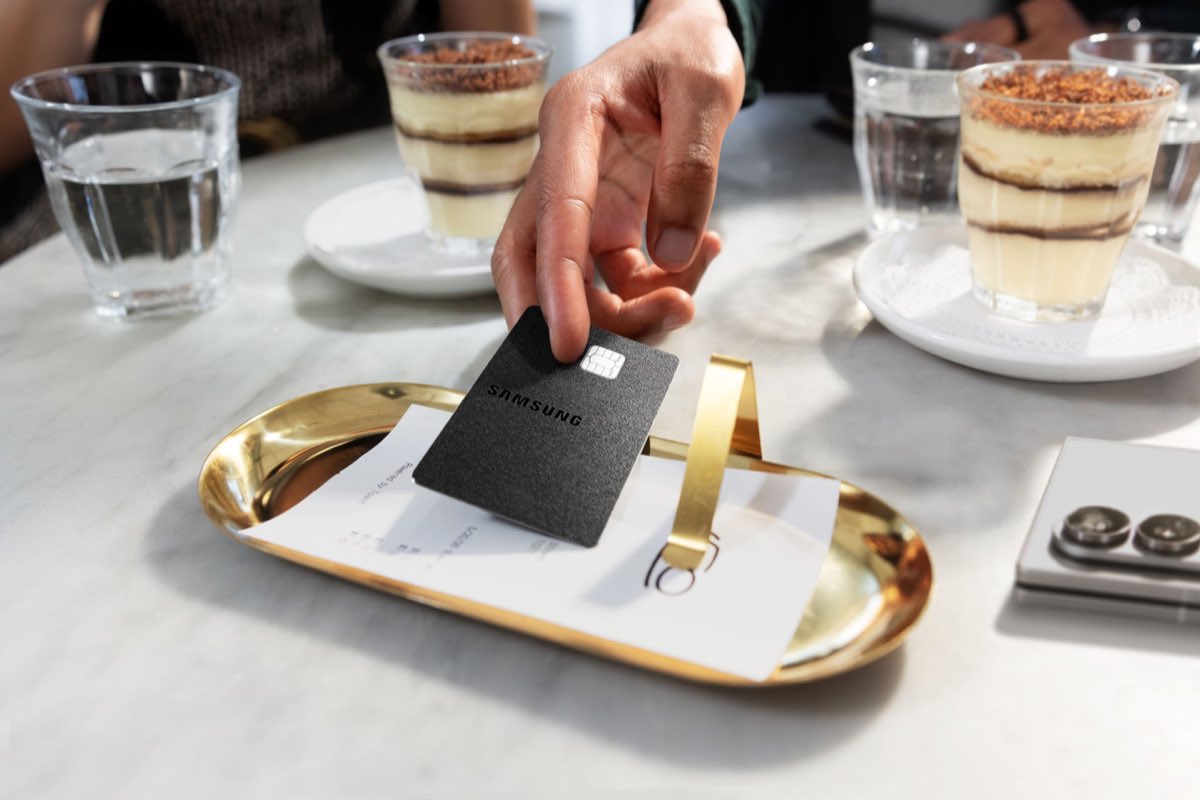 A person using the metal Samsung Galaxy Card at a restaurant