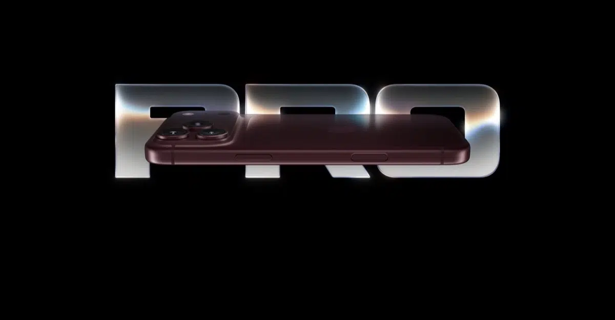 Burgundy iPhone Pro resting across large 'PRO' lettering on a black background.